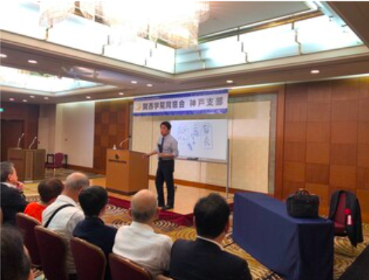 関西学院大学の同窓会で講演をする高岡達之