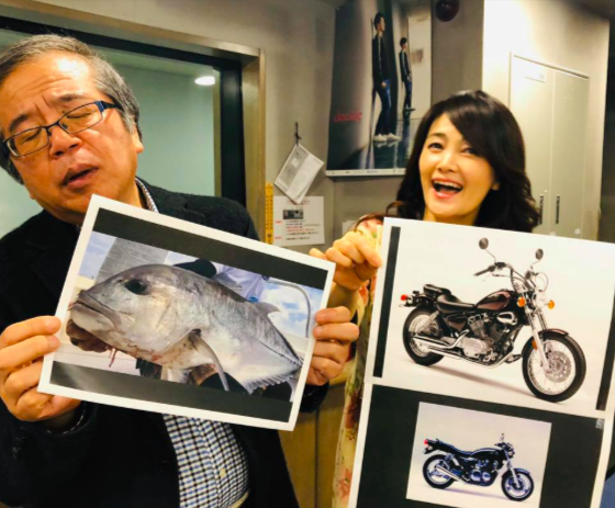 バイクの写真を掲げる内山佳子（右）