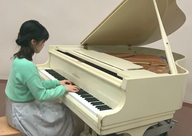 ピアノを弾く弦間彩華